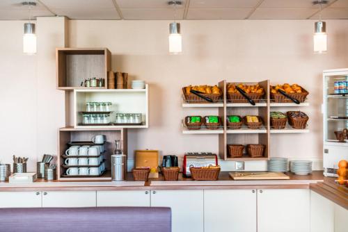a kitchen with a counter with baskets of food at Ace Hôtel Paris Sud Villabe in Villabé