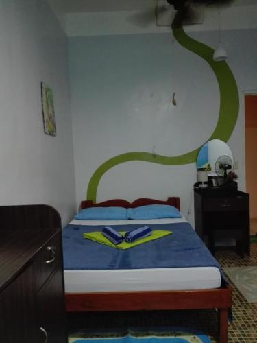 a bedroom with a bed with a green swirl on the wall at Toni Arts Villa in Nabas