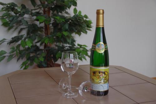 a green bottle of wine next to a wine glass at Gästehaus Steuer in Kröv