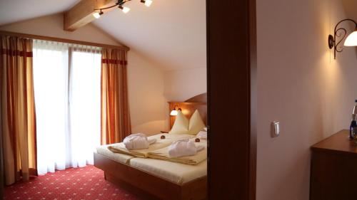 a hotel room with a bed and a window at Kurhotel Falter in Bad Reichenhall
