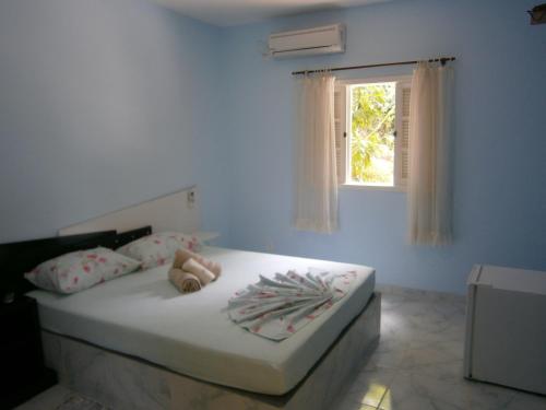 Bett in einem blauen Zimmer mit Fenster in der Unterkunft Pousada do Horto in Trindade