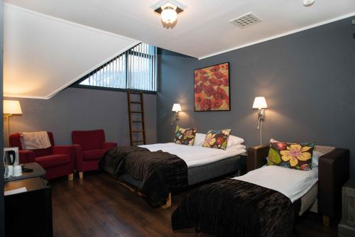 a hotel room with two beds and a chair at Flåmsbrygga Hotel in Flåm