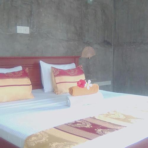 a large bed with two pillows and a box on it at La Perla Bentota in Bentota