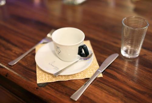 a coffee cup on a napkin next to a glass at Penzion Prelat in Český Krumlov