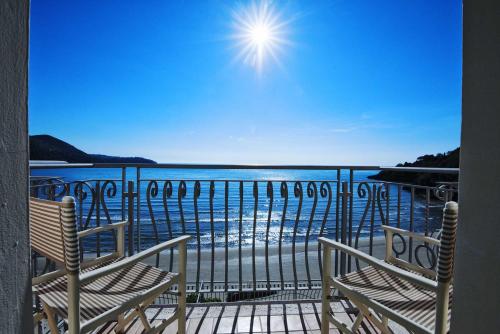 a balcony with two chairs and a view of the water at Grand Hotel Il Ninfeo in Gaeta