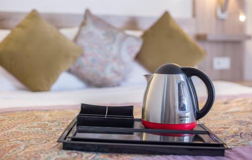 a coffee pot on a tray on a table with a bed at Arsi Enfi City Beach Hotel in Alanya