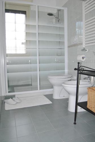 a white bathroom with a shower and a toilet at Villa Aurora B&B in Bari