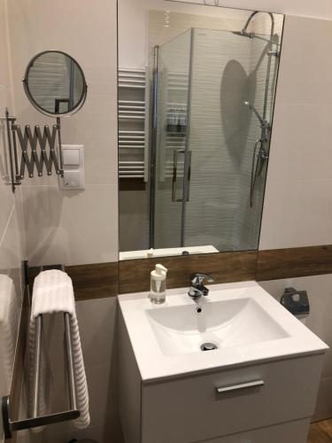 a bathroom with a white sink and a shower at Dworcowa - Apartament in Bydgoszcz