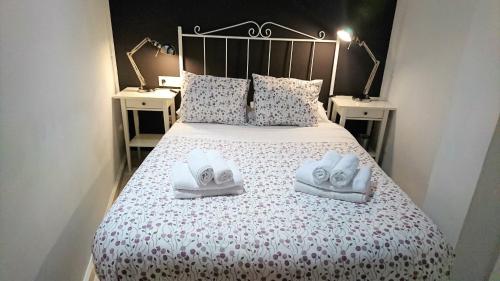 Un dormitorio con una cama con dos pares de zapatos. en Apartamentos PuntoApart Málaga, en Málaga