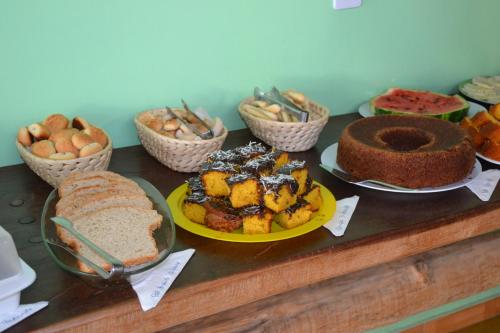 a table topped with different types of bread and pastries at Pousada dos Guias in Alto Paraíso de Goiás