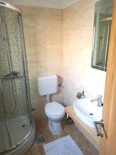 łazienka z toaletą, umywalką i prysznicem w obiekcie Apartments Grgic w Trogirze