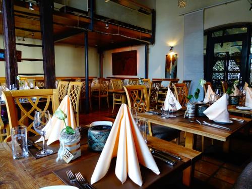 a restaurant with wooden tables and chairs with napkins on them at Salischer Hof in Schifferstadt