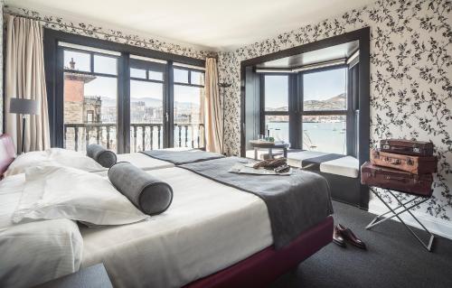 1 dormitorio con 2 camas y ventana grande en Ercilla Embarcadero Hotel en Getxo