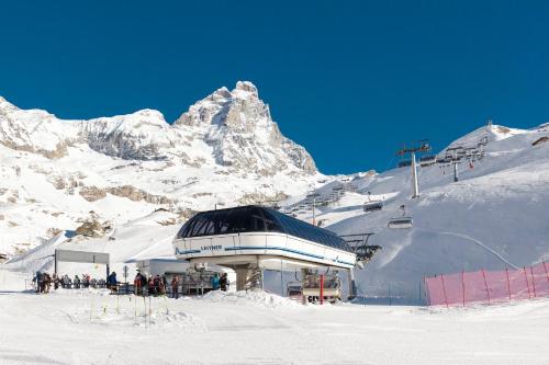 a building on top of a snow covered mountain at HelloChalet - Maison Rêve Blanc - Ski to door with Matterhorn view in Breuil-Cervinia