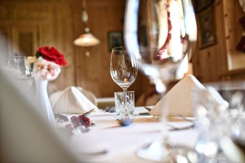a table with a wine glass on top of it at Hotel MARIA THERESIA adults-only in Lagundo
