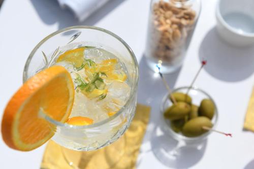 a drink in a glass with an orange slice at Hotel MARIA THERESIA adults-only in Lagundo