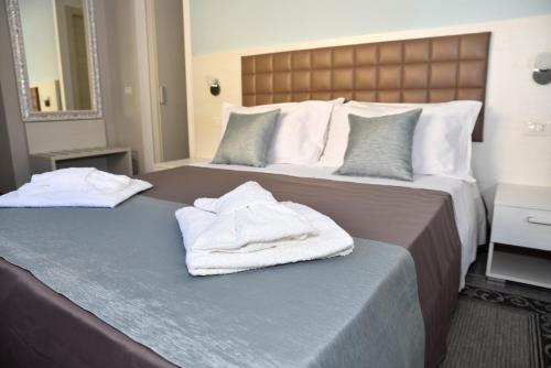 two beds in a hotel room with towels on them at DolceLina Home in Lampedusa