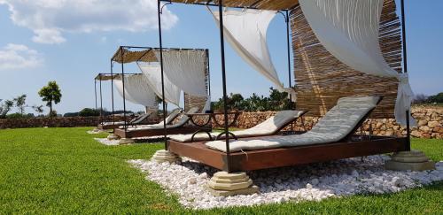 a row of chaise lounges in the grass at Masseria Cisternella in Alliste