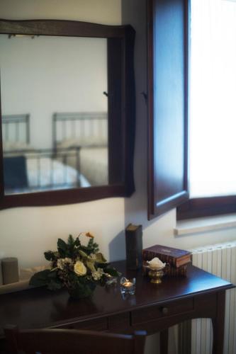 a table with a vase of flowers and a mirror at Convento San Bernardino in Montefranco