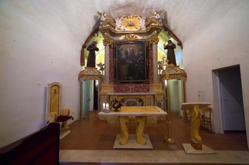 a altar in a room with a clock on the wall at Convento San Bernardino in Montefranco