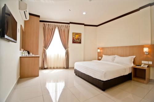 ein Hotelzimmer mit einem Bett und einem Fenster in der Unterkunft Hotel Setia in Keluang