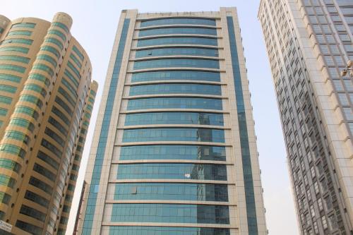 dois edifícios altos com janelas de vidro numa cidade em Clifton International Hotel em Fujairah