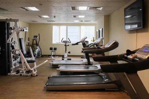 a gym with several tread machines in a room at Clifton International Hotel in Fujairah