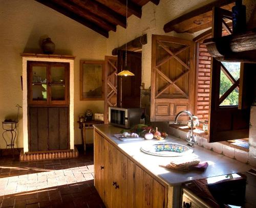 cocina con armarios de madera, fregadero y encimera en Molino Rio Alajar, en Alájar