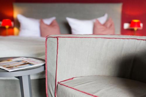 a room with a bed and a table with a chair at Seehotel Luitpold in Tegernsee
