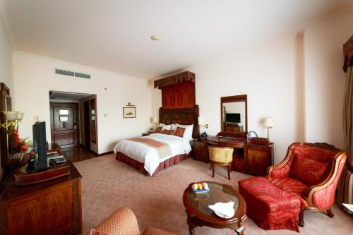 a bedroom with a bed and a desk and a couch at Islamabad Serena Hotel in Islamabad