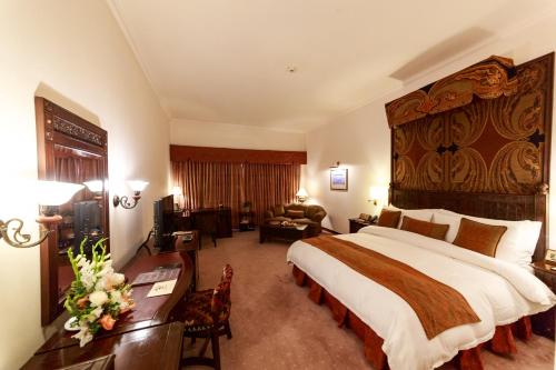 a hotel room with a large bed and a desk at Islamabad Serena Hotel in Islamabad