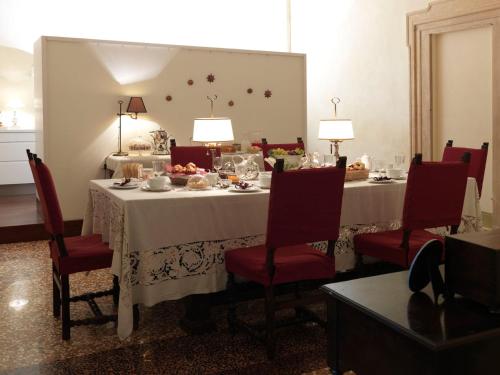 a dining room with a white table with red chairs at Antica Casa Zucchini B&B in Bologna