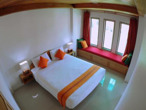 ein Schlafzimmer mit einem großen Bett und zwei Fenstern in der Unterkunft Sulawesi Castle in Rantepao