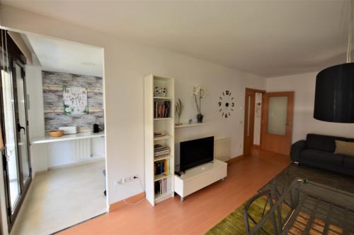 a living room with a couch and a television at Apartamento CERCA PLAYA CON BALCON Y BBQ in Calafell