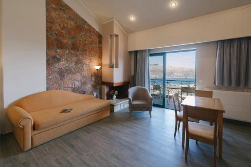a living room with a couch and a table and chairs at Giannis Village Resort in Astakós