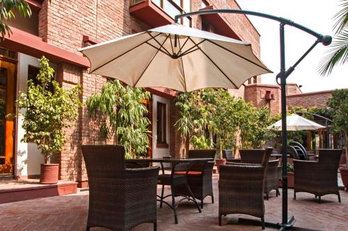 a table and chairs with an umbrella on a patio at Faisalabad Serena Hotel in Faisalabad