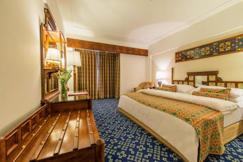 a hotel room with two beds and a window at Faisalabad Serena Hotel in Faisalabad