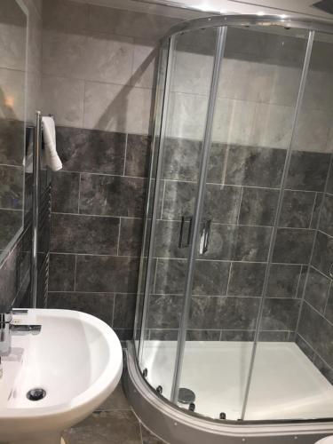 a bathroom with a shower and a sink at The Kellbank in Gosforth
