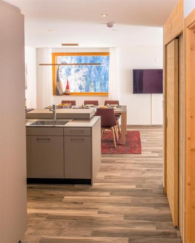 a kitchen with a sink and a table at Chalet Les Rahâs by Mrs Miggins in Grimentz