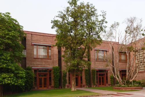a brick building with a tree in front of it at Faisalabad Serena Hotel in Faisalabad