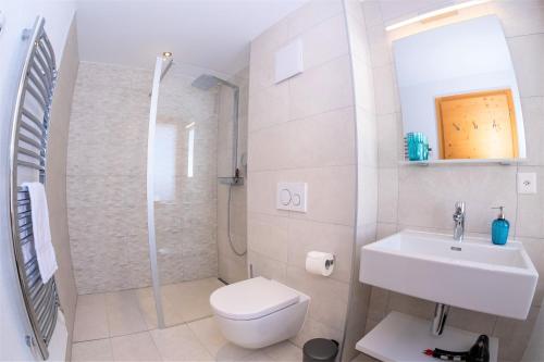 a bathroom with a toilet and a sink and a shower at Chalet Les Rahâs by Mrs Miggins in Grimentz