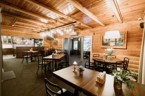 RubeneにあるGuest House Mazais Ansisの木製の壁とテーブルと椅子が備わるレストラン