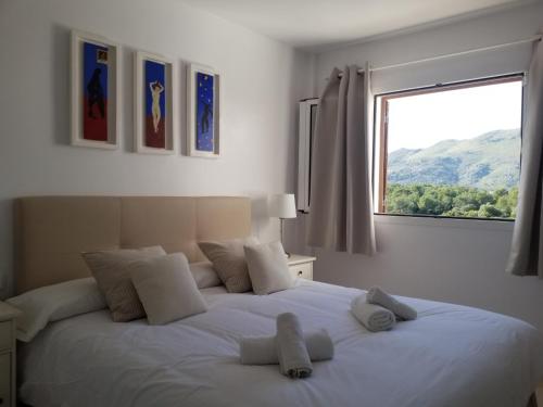 a bedroom with a large white bed with a window at Sea Two in Port de Pollensa