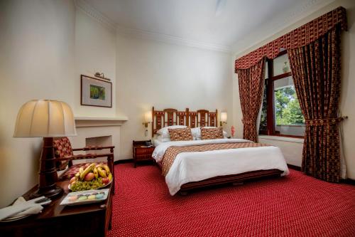 a bedroom with two beds and a table with a bowl of fruit at Swat Serena Hotel in Saidu