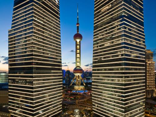 a view of the oriental pearl tower from between two tall buildings at IFC Residence in Shanghai