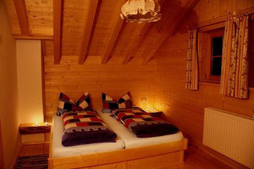 a bedroom with a bed in a wooden room at Lechtaler Naturparkchalets in Gramais