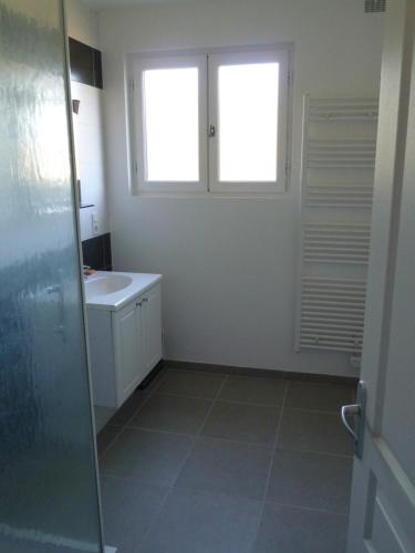 ein Bad mit einem Waschbecken und einem Fenster in der Unterkunft Longère en Sologne 2 in La Boullaye