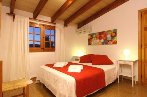 ein Schlafzimmer mit einem Bett mit einer roten Decke in der Unterkunft Roig Miquel house just 10m driving from Pollensa in Pollença