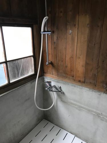 a shower in a bathroom with a tub at Guesthouse Matsushiro Walkers in Nagano