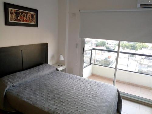 1 dormitorio con cama y ventana grande en Monoambiente Barrio Martin en Rosario